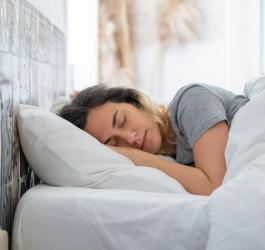 Kobieta śpi w łóżku.