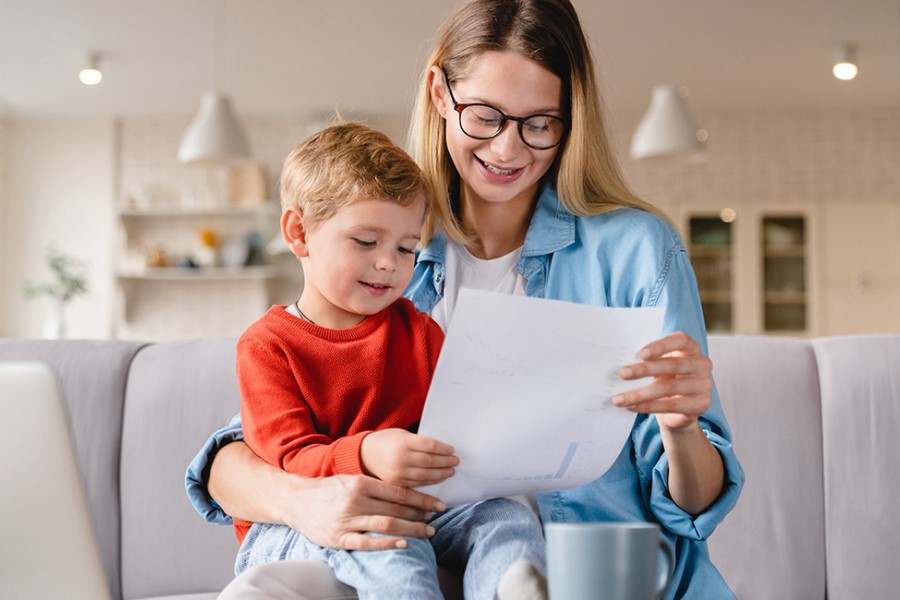 Młoda mama z małym dzieckiem przeglądają ofertę ubezpieczenia NNW dla dziecka