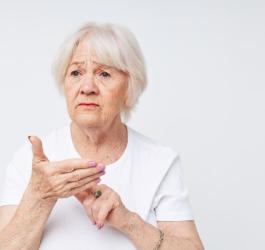 Starsza, zmartwiona kobieta zmagająca się z afazją.