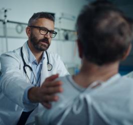 Lekarz na sali szpitalnej rozmawia z pacjentem chorym na amyloidozę.