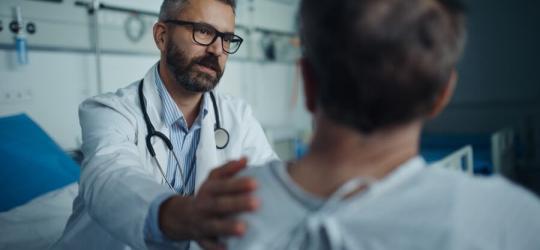 Lekarz na sali szpitalnej rozmawia z pacjentem chorym na amyloidozę.