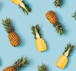 Owoce ananasa - w całości i przekrojone na pół.