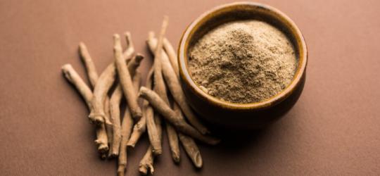 Korzenie oraz sproszkowana ashwagandha w miseczce.