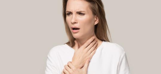 Kobieta zmaga się z objawami astmy aspirynowej.