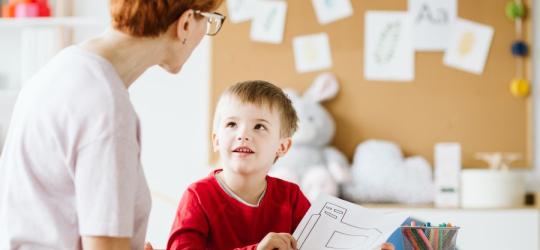 Terapeutka podczas zajęć z dzieckiem znajdującym się w spektrum autyzmu.