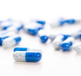 Niebiesko-białe kapsułki zawierające antybiotyk azytromycynę.