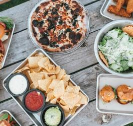 Rozmaite dania i przekąski postawione na drewnianym stole.