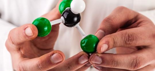 Naukowiec trzyma w dłoniach model budowy chloroformu.