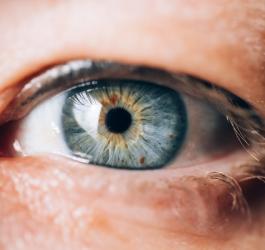Zbliżenie na ludzkie oko z niebieską tęczówką.