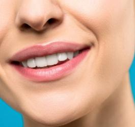 Zbliżenie na usta i nos uśmiechniętej kobiety.