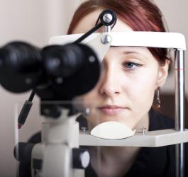 Kobieta w trakcie badania okulistycznego, będącego częścią diagnostyki chorób oczu.