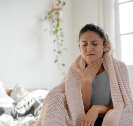 Kobieta trzyma się za szyję, dokucza jej ciągłe drapanie w gardle.
