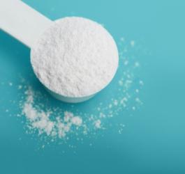 Biała miarka wypełniona sproszkowaną cytruliną.