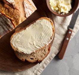 Kromki chleba posmarowane grubą warstwą masła.