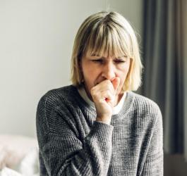 Kobieta kaszle, męczy ją suchy kaszel.