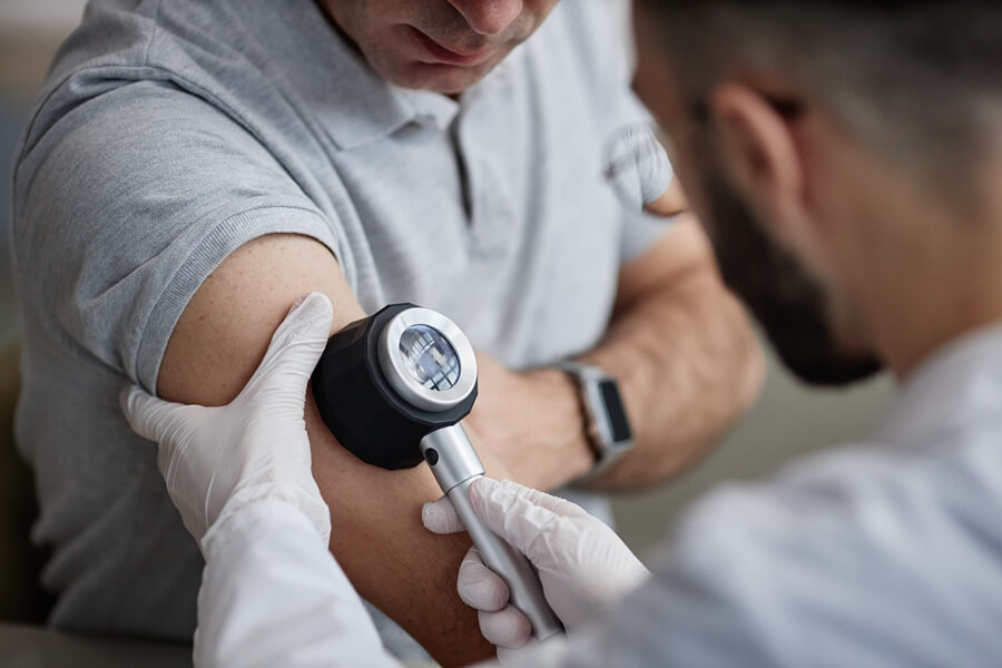 Dermatolog wykonuje u pacjenta dermatoskopię.