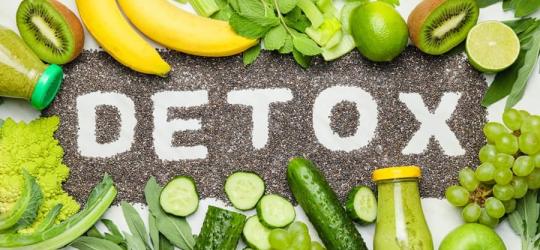 Świeże warzywa i owoce, rozsypana nasiona chia z napisem DETOX.