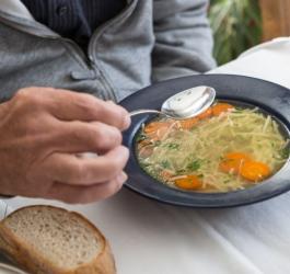 Starsza osoba zjada lekki posiłek zgodny z zasadami diety lekkostrawnej.