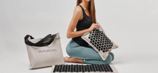 Kobieta korzysta z maty do akupresury.