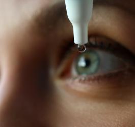 Kobieta zakrapla oko kroplami z ektoiną.