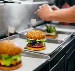 Kucharz przygotowuje popularny fast food - hamburgery.