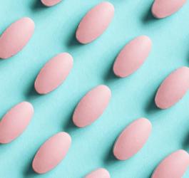 Różowe tabletki na błękitnym tle.