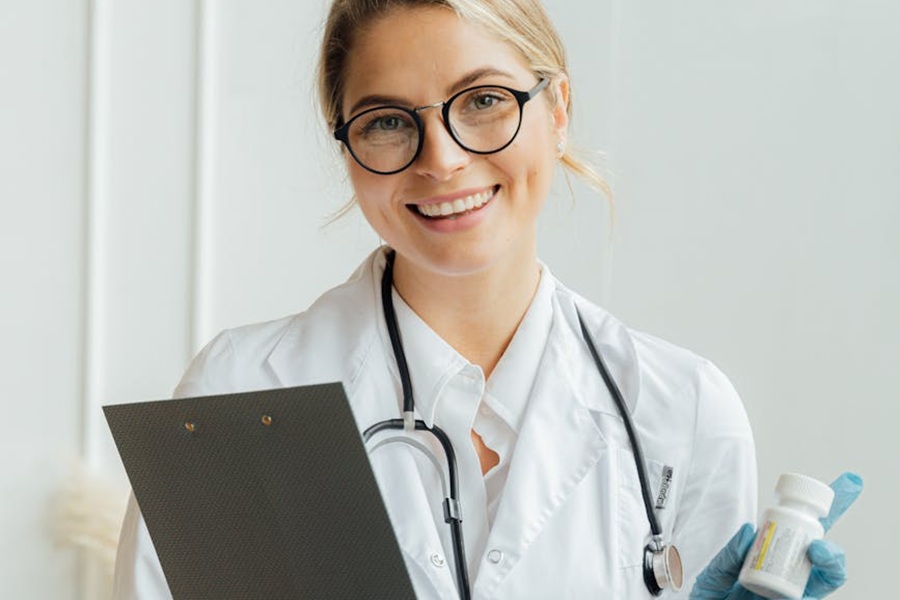 usmiechnieta lekarka trzmajace leki i stetoskop