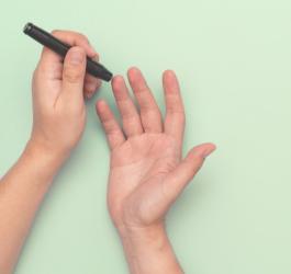 Osoba wykonuje pomiar glukozy przy pomocy glukometru.