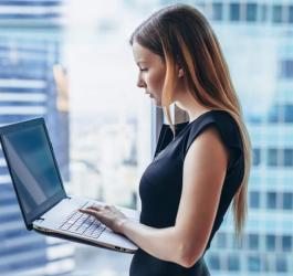 Młoda kobieta korzysta z laptopa w biurze.