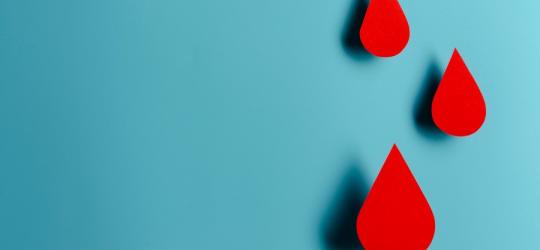 Rysunkowe krople krwi na niebieskim tle.