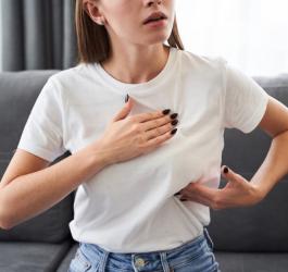 Kobieta dotyka bolącej piersi, może zmagać się z hiperprolaktynemią.