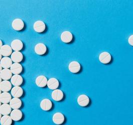 Tabletki z hydroksyzyną na turkusowym tle.