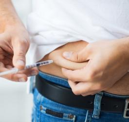 Mężczyzna chory na cukrzycę wstrzykuje sobie insulinę w okolicy brzucha.