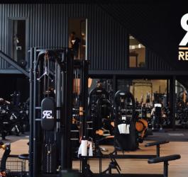 Siłownia z licznymi sprzętami do ćwiczeń siłowych.