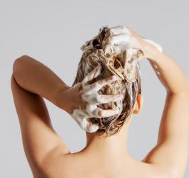 Kobieta wykonuje peeling skóry głowy.