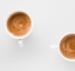 Dwa białe kubki z kawą bezkofeinową leżą na blacie kuchennym