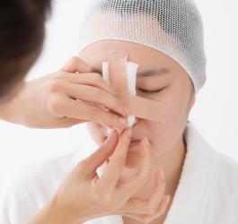 Kobieta u lekarza podczas konsultacji przed operacją nosa.