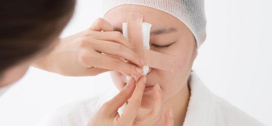 Kobieta u lekarza podczas konsultacji przed operacją nosa.