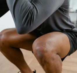 Mężczyzna wykonuje głęboki przysiad.