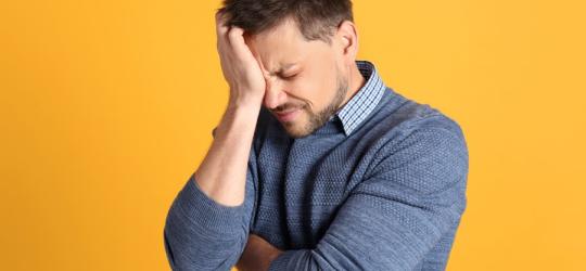Mężczyzna cierpi, zmaga się z klasterowym bólem głowy.