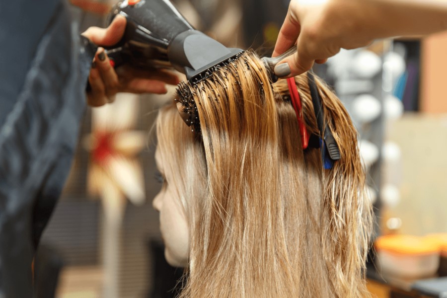 Kobieta u fryzjera podczas zabiegu poprawiającego kondycję włosów.