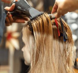 Kobieta u fryzjera podczas zabiegu poprawiającego kondycję włosów.