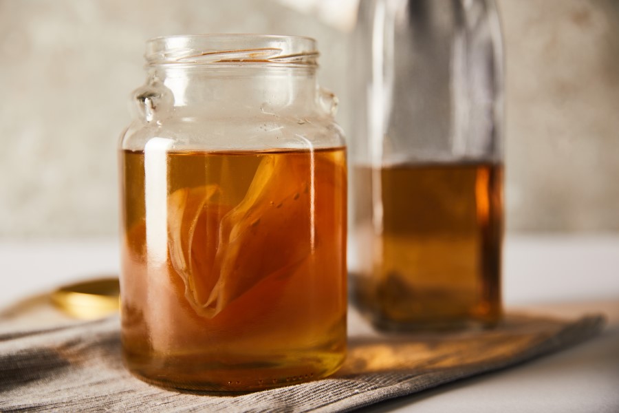 Kombucha w słoiku. W środku widoczny SCOBY, czyli grzyb herbaciany.