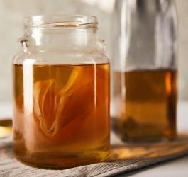 Kombucha w słoiku. W środku widoczny SCOBY, czyli grzyb herbaciany.