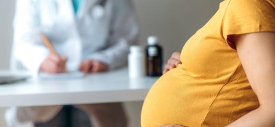 Kobieta w ciąży podczas wizyty lekarskiej u ginekologa.
