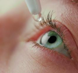 Kobieta aplikuje sobie krople do oczu.