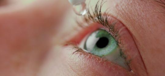 Kobieta aplikuje sobie krople do oczu.