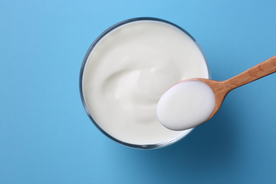 Szklanka z jogurtem, który jest źródłem kwasu mlekowego.