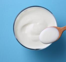 Szklanka z jogurtem, który jest źródłem kwasu mlekowego.