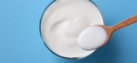 Szklanka z jogurtem, który jest źródłem kwasu mlekowego.